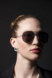 Портрет красивой молодой женщины в солнечных очках на черном backgro Стоковая Фотография Портрет красивой молодой женщины в солнечных очках на черном backgro Стоковая Фотография