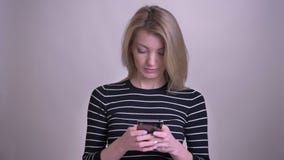 Портрет крупного плана отправки SMS взрослого привлекательного белокурого кавказца женской по телефону и усмехаться с изолированн видеоматериал Портрет крупного плана отправки SMS взрослого привлекательного белокурого кавказца женской по телефону и усмехаться с изолированн видеоматериал