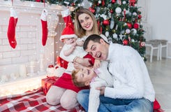 Портрет крупного плана семьи рождества Мама с newborn ребёнком и папой с сыном стоковое фото rf Портрет крупного плана семьи рождества Мама с newborn ребёнком и папой с сыном стоковое фото rf