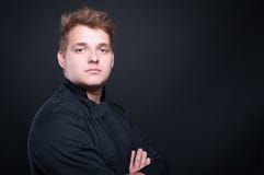 Портрет молодого шеф-повара представляя с сложенными оружиями стоковые изображения rf Портрет молодого шеф-повара представляя с сложенными оружиями стоковые изображения rf