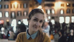 Портрет молодой красивой женщины стоя в центре города в вечере Девушка студента смотрит камеру, усмехаясь стоковые изображения rf Портрет молодой красивой женщины стоя в центре города в вечере Девушка студента смотрит камеру, усмехаясь стоковые изображения rf