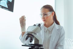 Портрет молодого исследования ученого используя микроскоп в работе стоковая фотография rf Портрет молодого исследования ученого используя микроскоп в работе стоковая фотография rf