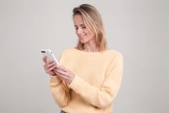 Портрет молодой белокурой усмехаясь женщины используя сотовый телефон, послание, был счастливый побеседовать с ее парнем o стоковое изображение rf Портрет молодой белокурой усмехаясь женщины используя сотовый телефон, послание, был счастливый побеседовать с ее парнем o стоковое изображение rf