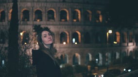 Портрет молодой женщины брюнет стоя около Colosseum в Риме, Италии в вечере Повороты и взгляды девушки на камере стоковая фотография rf Портрет молодой женщины брюнет стоя около Colosseum в Риме, Италии в вечере Повороты и взгляды девушки на камере стоковая фотография rf