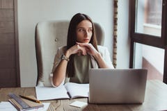 Портрет молодой коммерсантки сидя с ее компьтер-книжкой в офисе стоковое изображение rf Портрет молодой коммерсантки сидя с ее компьтер-книжкой в офисе стоковое изображение rf