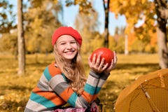 Портрет осени счастливой девушки в красных шляпе и свитере стоковые фотографии rf Портрет осени счастливой девушки в красных шляпе и свитере стоковые фотографии rf