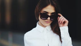 Портрет привлекательной девушки с пропуская черными волосами, она усмехается на камере акции видеоматериалы Портрет привлекательной девушки с пропуская черными волосами, она усмехается на камере акции видеоматериалы