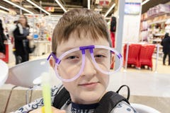 Портрет смешного милого мальчика нося странные стекла сделанные из дневных неоновых трубок, торгового центра стоковая фотография Портрет смешного милого мальчика нося странные стекла сделанные из дневных неоновых трубок, торгового центра стоковая фотография