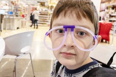 Портрет смешного милого мальчика нося странные стекла сделанные из дневных неоновых трубок, торгового центра стоковое изображение Портрет смешного милого мальчика нося странные стекла сделанные из дневных неоновых трубок, торгового центра стоковое изображение