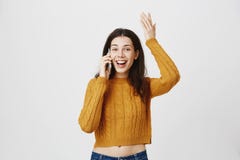 Портрет студии excited и изумленной руки женщины поднимаясь пока говорящ на smartphone, выражающ счастье и был стоковое фото rf Портрет студии excited и изумленной руки женщины поднимаясь пока говорящ на smartphone, выражающ счастье и был стоковое фото rf