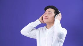 Портрет студии красивого молодого человека японской этничности и наушников видеоматериал Портрет студии красивого молодого человека японской этничности и наушников видеоматериал