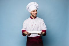 Портрет счастливого мужского положения повара шеф-повара с плитой изолированной на светлом - голубая предпосылка стоковое изображение Портрет счастливого мужского положения повара шеф-повара с плитой изолированной на светлом - голубая предпосылка стоковое изображение
