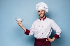 Портрет счастливого мужского положения повара шеф-повара с плитой изолированной на светлом - голубая предпосылка стоковые фотографии rf Портрет счастливого мужского положения повара шеф-повара с плитой изолированной на светлом - голубая предпосылка стоковые фотографии rf