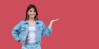 Портрет счастливой красивой молодой женщины брюнета с макияжем в положении непринужденного стиля джинсовой ткани, руки на copyspa стоковое изображение Портрет счастливой красивой молодой женщины брюнета с макияжем в положении непринужденного стиля джинсовой ткани, руки на copyspa стоковое изображение