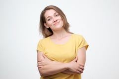 Портрет усмехаясь молодой европейской женщины стоя при сложенные оружия стоковые изображения Портрет усмехаясь молодой европейской женщины стоя при сложенные оружия стоковые изображения