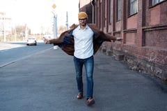 Портрет человека моды Молодой человек в стеклах нося пальто идя вниз по улице стоковая фотография Портрет человека моды Молодой человек в стеклах нося пальто идя вниз по улице стоковая фотография