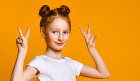 Портрет шикарной рыжеволосой девушки смотря камеру с улыбкой и показывая знак мира с пальцами стоковое изображение rf Портрет шикарной рыжеволосой девушки смотря камеру с улыбкой и показывая знак мира с пальцами стоковое изображение rf