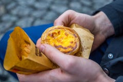 Португальский пирог яичка десерта (Pasteis de Nata) в руке человека, конце-вверх стоковое изображение rf Португальский пирог яичка десерта (Pasteis de Nata) в руке человека, конце-вверх стоковое изображение rf