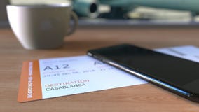 Посадочный талон к Касабланке и smartphone на таблице в авиапорте пока путешествующ к Марокко перевод 3d стоковая фотография Посадочный талон к Касабланке и smartphone на таблице в авиапорте пока путешествующ к Марокко перевод 3d стоковая фотография