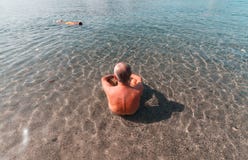 Постаретый человек принимая остатки на море в Италии - Сардинии стоковые фотографии rf Постаретый человек принимая остатки на море в Италии - Сардинии стоковые фотографии rf