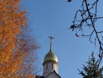 Правоверный крест обрамленный желтыми листьями осени деревьев стоковые изображения rf Правоверный крест обрамленный желтыми листьями осени деревьев стоковые изображения rf