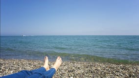 Праздники каникул Крупный план ног женщины девушки ослабляя на пляже на sunbed наслаждаясь солнце на солнечный летний день стоковые изображения Праздники каникул Крупный план ног женщины девушки ослабляя на пляже на sunbed наслаждаясь солнце на солнечный летний день стоковые изображения