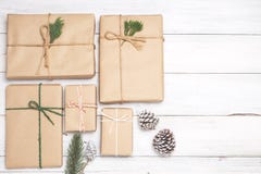 Предпосылка рождества с handmade присутствующими подарочными коробками и деревенское украшение на белой деревянной доске стоковые фотографии rf Предпосылка рождества с handmade присутствующими подарочными коробками и деревенское украшение на белой деревянной доске стоковые фотографии rf