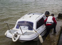 Предприниматель шлюпки принося его малую шлюпку стеклоткани к берегу в Warsash, Хемпшире к ждать трейлеру для того чтобы принять стоковое фото Предприниматель шлюпки принося его малую шлюпку стеклоткани к берегу в Warsash, Хемпшире к ждать трейлеру для того чтобы принять стоковое фото