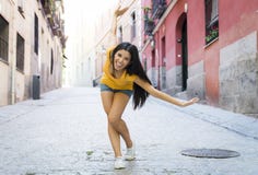 Представлять молодой привлекательной латинской женщины счастливый и excited на современном городском европейском городе стоковое изображение rf Представлять молодой привлекательной латинской женщины счастливый и excited на современном городском европейском городе стоковое изображение rf