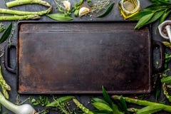 Предпосылка еды с открытым космосом для текста Травы, оливковое масло, специи вокруг литого железа жаря доску Взгляд сверху Стоковое Изображение Предпосылка еды с открытым космосом для текста Травы, оливковое масло, специи вокруг литого железа жаря доску Взгляд сверху Стоковое Изображение