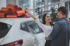 Прекрасные молодые женатые пары покупая новый автомобиль совместно стоковое фото rf Прекрасные молодые женатые пары покупая новый автомобиль совместно стоковое фото rf