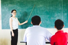 Преподавательство учителя в классе с предпосылкой доски стоковые фото Преподавательство учителя в классе с предпосылкой доски стоковые фото