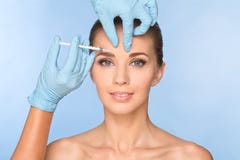 Привлекательная молодая женщина получает косметическую впрыску botox стоковое фото rf Привлекательная молодая женщина получает косметическую впрыску botox стоковое фото rf