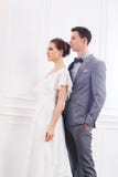 Привлекательная невеста в белом платье и красивом groom в сером цвете Стоковое фото RF Привлекательная невеста в белом платье и красивом groom в сером цвете Стоковое фото RF