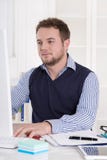 Привлекательная удовлетворенная академичная работа на компьютере на офисе. стоковые изображения rf Привлекательная удовлетворенная академичная работа на компьютере на офисе. стоковые изображения rf