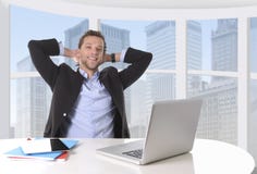 Привлекательный бизнесмен счастливый на усмехаться работы ослабил на районном отделении компьютерного бизнеса Стоковые Изображения RF Привлекательный бизнесмен счастливый на усмехаться работы ослабил на районном отделении компьютерного бизнеса Стоковые Изображения RF