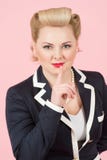 Привлекательная белокурая девушка с стилем причёсок штыря-вверх курчавым с пальцем на ее красных губах заволакивание предпосылки стоковое изображение rf Привлекательная белокурая девушка с стилем причёсок штыря-вверх курчавым с пальцем на ее красных губах заволакивание предпосылки стоковое изображение rf