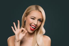 привлекательная белокурая подмигивая женщина показывая знак okey, стоковая фотография rf привлекательная белокурая подмигивая женщина показывая знак okey, стоковая фотография rf