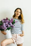 Привлекательная девушка с фиолетовым букетом сирени на белой предпосылке стоковые фотографии rf Привлекательная девушка с фиолетовым букетом сирени на белой предпосылке стоковые фотографии rf