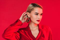 привлекательная модная девушка представляя в красных куртке и серьгах, стоковые изображения rf привлекательная модная девушка представляя в красных куртке и серьгах, стоковые изображения rf