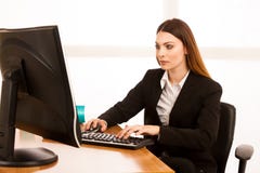 Привлекательная молодая бизнес-леди работает на ее столе в офисе стоковое изображение rf Привлекательная молодая бизнес-леди работает на ее столе в офисе стоковое изображение rf