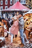 Привлекательная пара в любов, имеющ потеху совместно на ярмарке рождества стоковое изображение rf Привлекательная пара в любов, имеющ потеху совместно на ярмарке рождества стоковое изображение rf