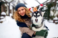 Привлекательная подлинная кавказская женщина обнимает смешную собаку malamute нося antlers рождества santa дорогие Курчавая усмех стоковые фото Привлекательная подлинная кавказская женщина обнимает смешную собаку malamute нося antlers рождества santa дорогие Курчавая усмех стоковые фото
