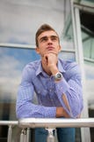 Привлекательный молодой человек на предпосылке офисного здания Серьезный корпоративный работник с вахтой доллар принципиальной сх стоковые изображения Привлекательный молодой человек на предпосылке офисного здания Серьезный корпоративный работник с вахтой доллар принципиальной сх стоковые изображения