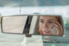 Приводы молодой женщины автомобиль и беседы по телефону стоковые фотографии rf Приводы молодой женщины автомобиль и беседы по телефону стоковые фотографии rf