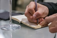 Примечания почерка человека во время дегустации вин стоковое изображение Примечания почерка человека во время дегустации вин стоковое изображение