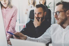 Принципиальная схема сыгранности Молодые сотрудники обсуждая новое дело проектируют в современном офисе Группа в составе 3 люд ан стоковая фотография Принципиальная схема сыгранности Молодые сотрудники обсуждая новое дело проектируют в современном офисе Группа в составе 3 люд ан стоковая фотография
