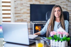 Пробуренная молодая женщина в офисе работая с ноутбуком стоковое фото rf Пробуренная молодая женщина в офисе работая с ноутбуком стоковое фото rf