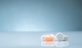 Продукт аптеки фармации Куча оранжевой и белой таблетки планшетов на предпосылке градиента Различные таблетки планшетов размера и стоковое фото rf Продукт аптеки фармации Куча оранжевой и белой таблетки планшетов на предпосылке градиента Различные таблетки планшетов размера и стоковое фото rf
