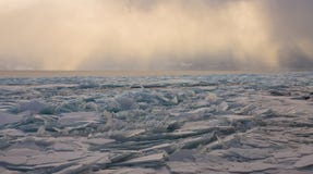 Прозрачные торошения льда Байкала на заходе солнца в тумане Стоковые Изображения Прозрачные торошения льда Байкала на заходе солнца в тумане Стоковые Изображения